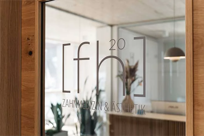 Glastür mit dem Zeichen [fh20] Zahnmedizin und Ästhetik